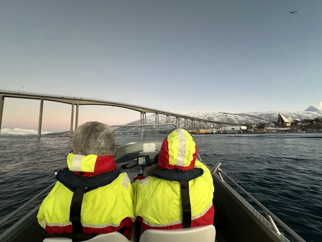 A couple enjoying a view of Tromsø bridge and Arctic cathedral on a private boat tour in Tromsø