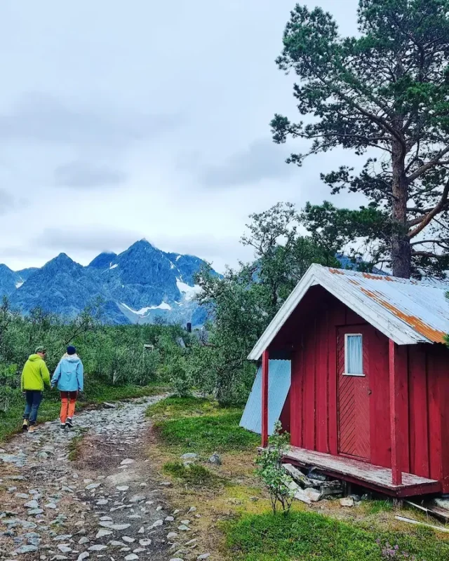 A couple in colorful clothing hiking down a stony path in Lyngen alps