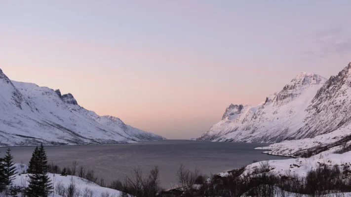 Snow-covered, steep peaks of mountains in Ersfjord at sunset in Northern Norway