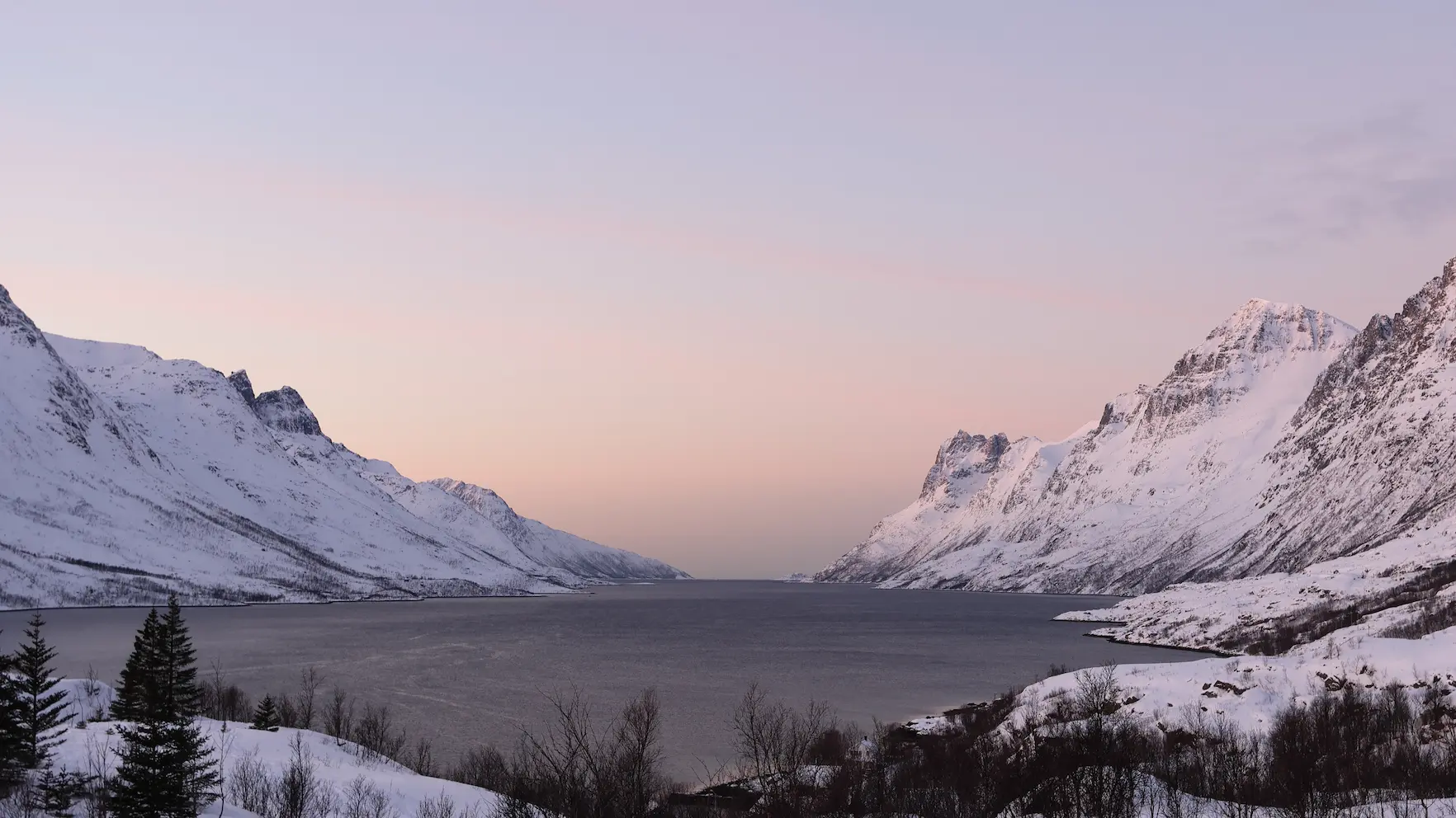 Snow-covered, steep peaks of mountains in Ersfjord at sunset in Northern Norway