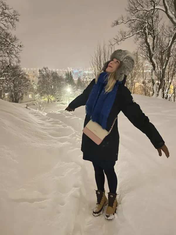 Girl enjoying snow during a beautiful night in Tromsø