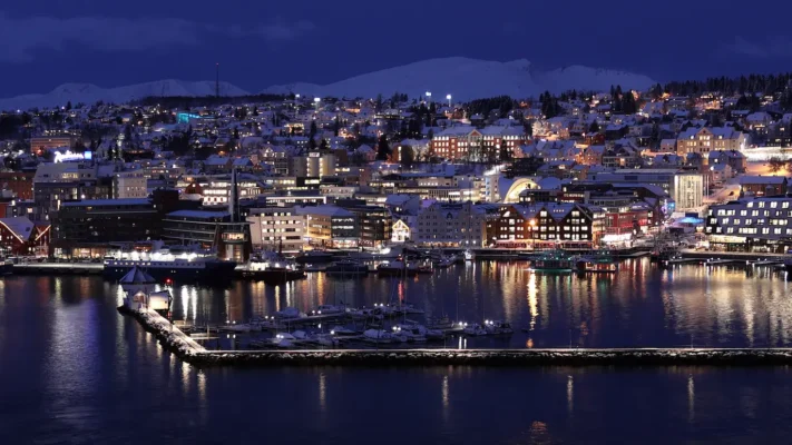 Winter evening view of Tromsø city and harbour lit up at night