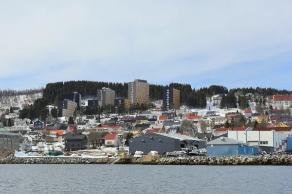 Colorful hillside houses and modern buildings overlooking Tromsø harbour on a clear winter day