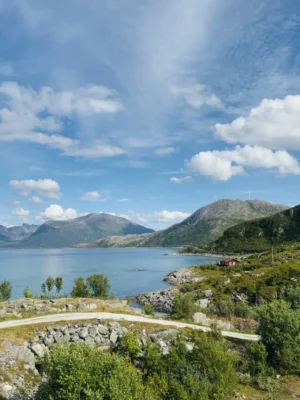 Beautiful fjord landscape with mountains and a red cabin seen on a Sommarøy tour near Tromsø, Norway.