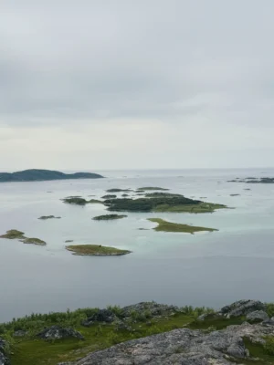 Panoramic view of small islands and turquoise waters from the top of Ørnfløya near Sommarøy, Tromsø, Norway.