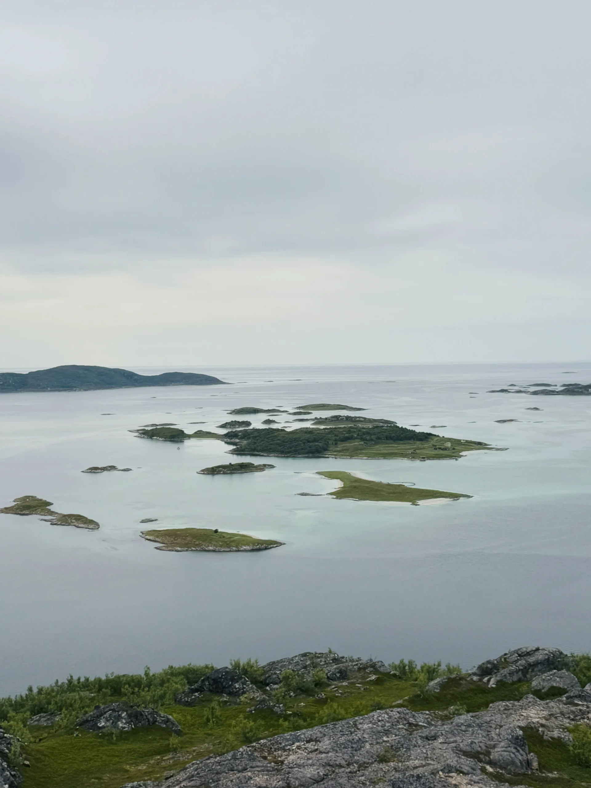 Panoramic view of small islands and turquoise waters from the top of Ørnfløya near Sommarøy, Tromsø, Norway.