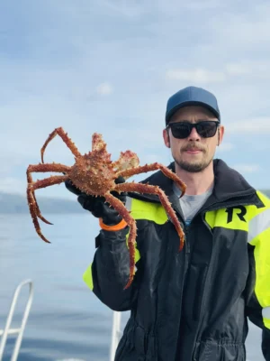 Person holding a large king crab during a private King Crab Tour in Tromsø, Norway.