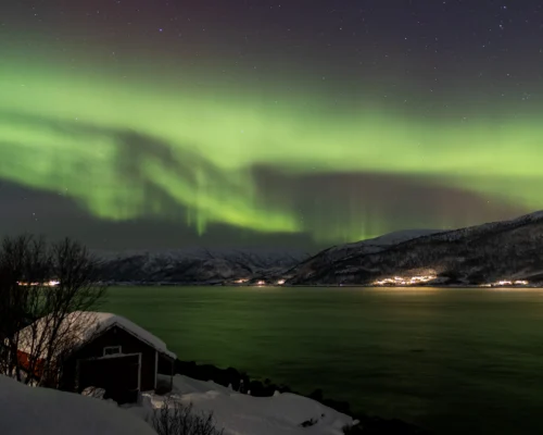 Northern Lights over a fjord near Tromsø during a private Northern Lights tour